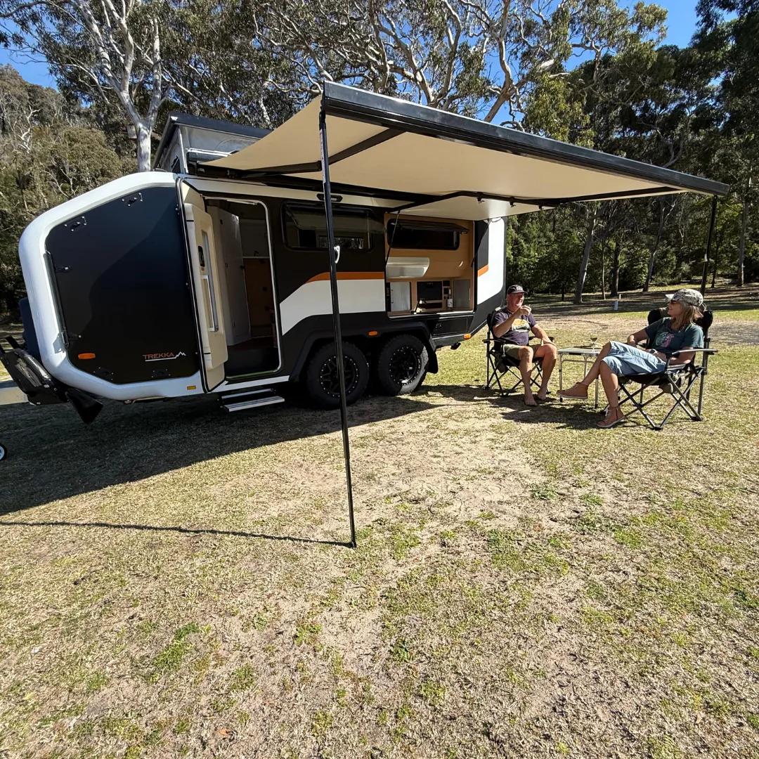 Trekka 01 set up at camp with awning, table and chairs
